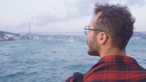 Man-traveling-on-a-ferry-against-the-Bosphorus-view.-Istanbul-city.